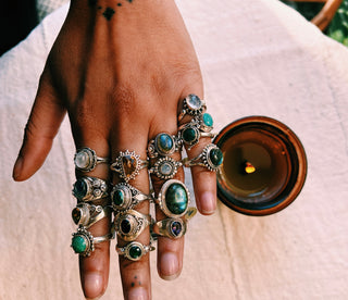 many rings of assorted stones and sizes on a hand