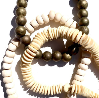 African bead strands in multiple styles, brass, white bone, and disc shaped.
