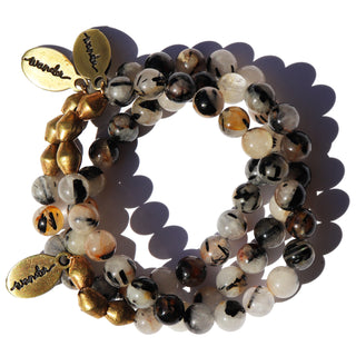 a beautiful combination of clear quartz and black tourmaline beads, brass accent beads and an Often Wander charm.