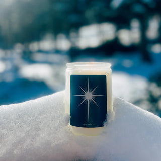 A 12oz frosted jar with a black and white label that displays a white star. The scent is cypress, plum, musk, and white currant. Made with soy wax.