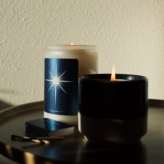 two candles burning on a shadowy brass shelf