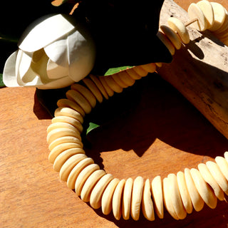 African bead strands, a cream color in a disc shape.