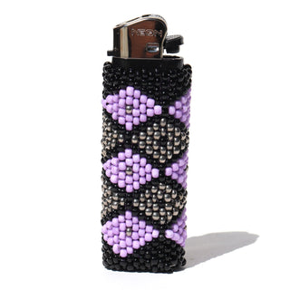 A lighter covered in a handmade beaded sleeve featuring a geometric pattern of black, silver, and light purple beads, shown on a white background.