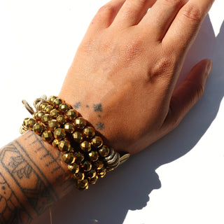 shiny gold hematite with brass accent beads and an Often Wander charm.