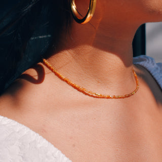 petite golden tourmaline beads with a few gold accent beads. The 14k Gold Fill chain is adorned with a draping “Often Wander” charm down the back.