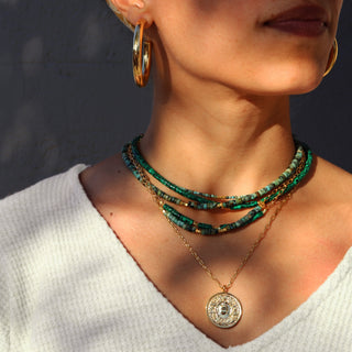 green turquoise stone beads with a few gold beaded accents. 14k Gold Fill chain is adorned with a draping “Often Wander” charm down the back.