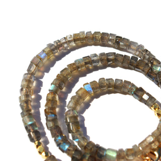 bold labradorite beads that are grey with flashes of blue in the light along with gold accent beads & The 14k Gold Fill chain is adorned with a draping “Often Wander” charm down the back.
