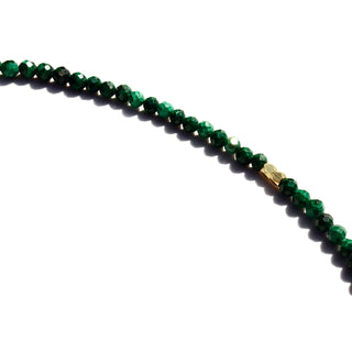 Petite malachite faceted stone strung together with tiny gold spacers beads mixed amongst them.
