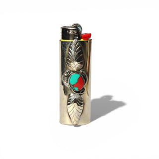 Decorative lighter with a leaf design and colored stones on a white background