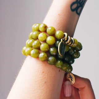 Faceted olive jade beads with a few brass accent beads and a brass Often Wander charm.