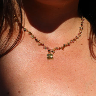 A petite faceted rain tourmaline bead dangling from a 14k gold fill chain with a mini squared charm with an evil eye stamped into the charm.