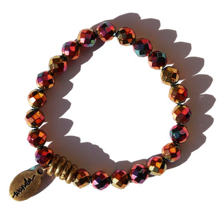 shiny metallic faceted rainbow beads with colors of magenta, pink, purple, orange and gold with brass accent beads and a small Often Wander charm.