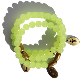 neon green glass  beads with brass accent beads and an Often Wander charm.