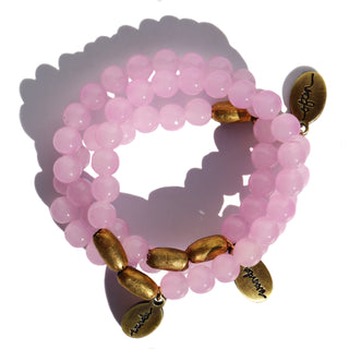neon pinky purple glass beads with a few brass accent beads. along with an Often Wander brass charm